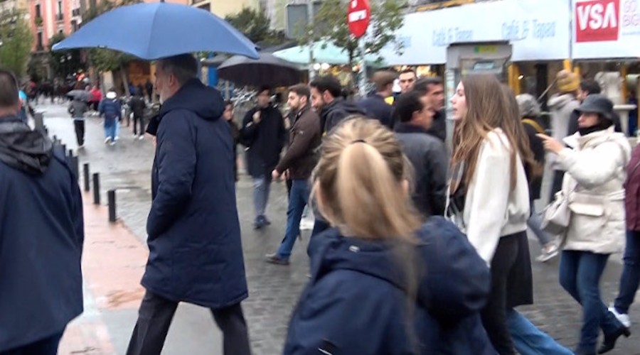 Los Reyes y sus hijas disfrutan de un paseo por la capital pasado por agua